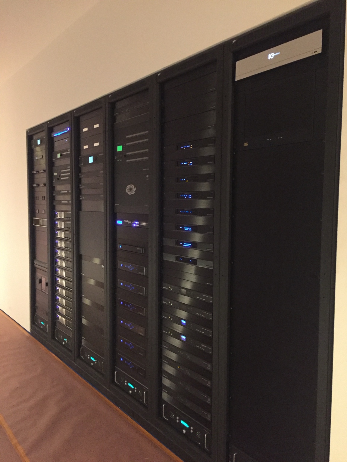 A bank of neatly integrated residential technology equipment racks
